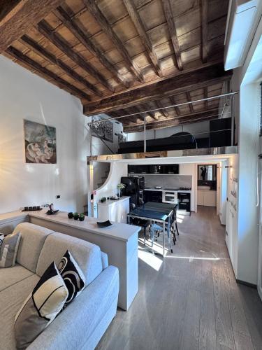 a living room and kitchen with a couch and a table at Suite Burotti - Cherasco in Cherasco