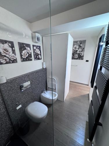 a bathroom with a toilet and a glass shower at Suite Burotti - Cherasco in Cherasco