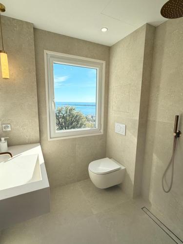 une salle de bain avec un lavabo et des toilettes et une fenêtre dans l'établissement Panoramic Sea View Cannes renovated 3 bedrooms - Swimming Pool, à Cannes