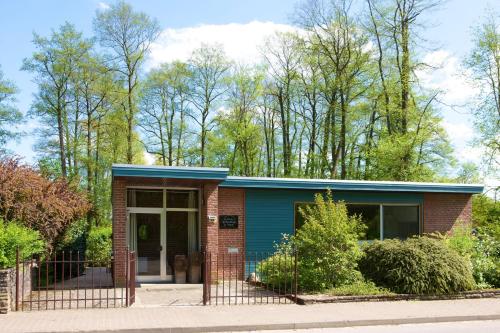 een klein bakstenen gebouw met een blauw dak bij Haus am Moorbeek in Eimke