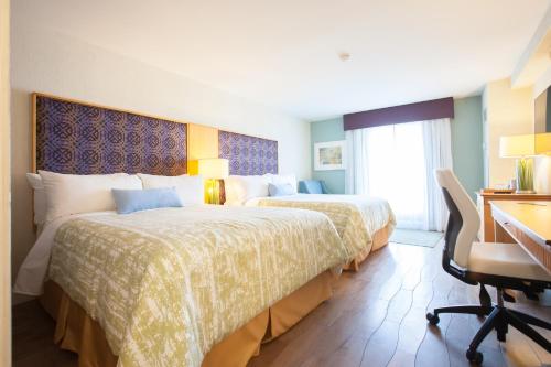 a hotel room with two beds and a desk at Best Western Premier Toronto Airport Carlingview Hotel in Toronto