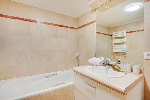 une salle de bain avec un lavabo et une baignoire dans l'établissement Charmant studio 30 m2 proche Hôpital américain, à Levallois-Perret