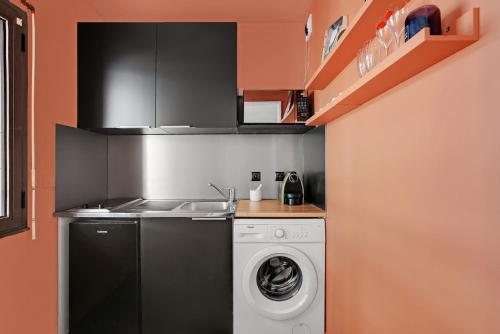une cuisine avec une machine à laver et un évier dans l'établissement Charmant studio 30 m2 proche Hôpital américain, à Levallois-Perret