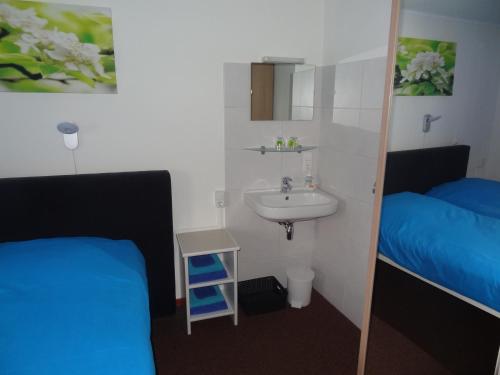 a bathroom with two beds and a sink and a mirror at 't Reijmerhöfke in Reijmerstok