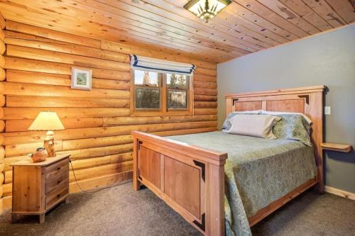Un dormitorio con una cama en una cabaña de troncos en Amazing Secluded Cabin On 10 Acres, Close To Breck, en Fairplay