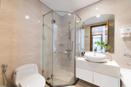 een badkamer met een douche, een toilet en een wastafel bij Cozy Nest Vinhomes in Ho Chi Minh-stad