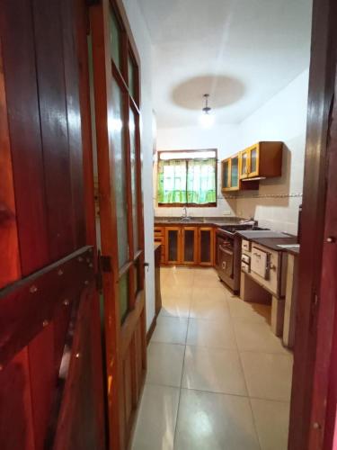 a kitchen with wooden cabinets and a large open door at El Salvador in Chascomús