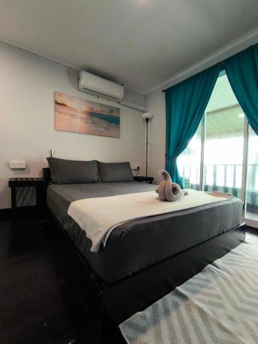a bedroom with a bed with a teddy bear on it at Seahorse Diver Guesthouse in Perhentian Islands