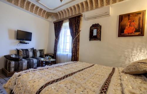 a bedroom with a bed and a couch at Riad Salam Fes in Fès