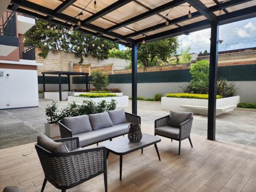 a patio with a couch and two chairs and a table at Skyline Penthouse 901 in Quetzaltenango