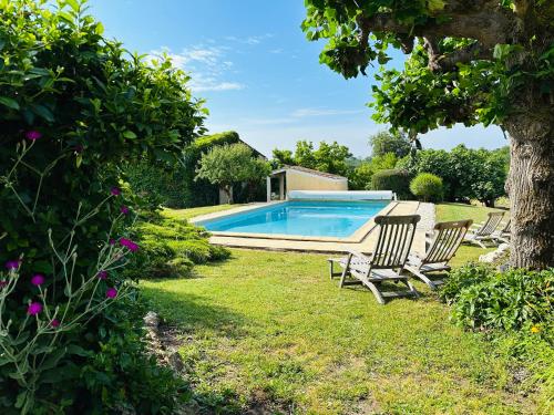 - une piscine dans une cour avec 2 chaises et un arbre dans l'établissement Relais-LG, à Saint-Caprais-de-Bordeaux