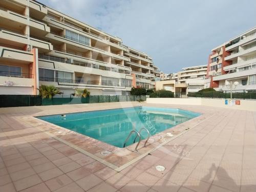 - une piscine en face d'un immeuble dans l'établissement T2 COIN CHAMBRE, TERRASSE 1ERE LIGNE MER, PISCINE, à Sète