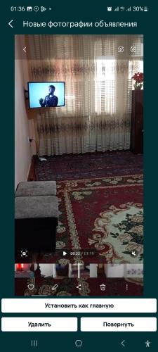 un soggiorno con televisione e divano di Квартире ad Andijan