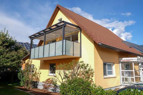 Una casa amarilla con balcón en la parte superior. en Fewo Kiefer, en Bad Krozingen