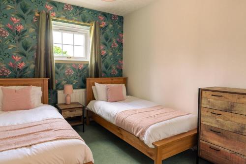 zwei Einzelbetten in einem Zimmer mit Fenster in der Unterkunft Wetheral at Wetheral Cottages in Great Salkeld