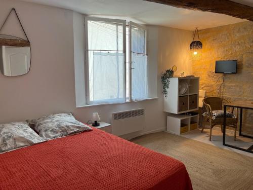 - une chambre avec un lit rouge et une fenêtre dans l'établissement Studio Cosy Rue piètonne calme Centre-ville d'Uzès, à Uzès