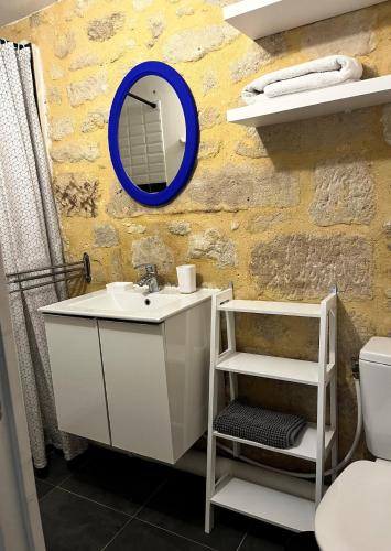 une salle de bain avec un lavabo et un miroir au mur dans l'établissement Studio Cosy Rue piètonne calme Centre-ville d'Uzès, à Uzès