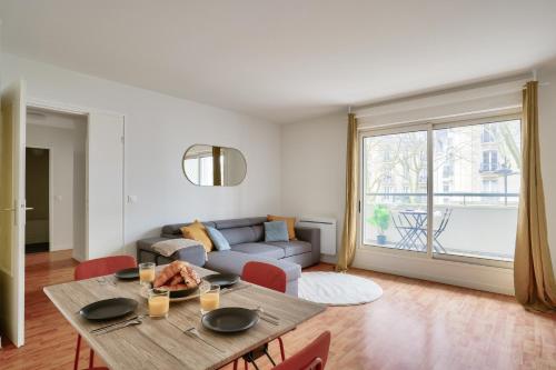 un salon avec une table et un canapé dans l'établissement New & Cozy T2 with Balcony - Paris 18 Montmartre, à Paris