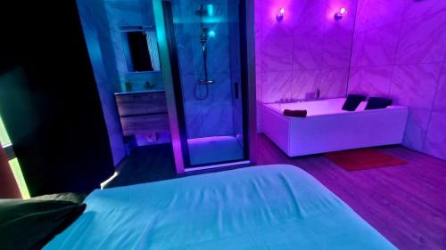 a purple room with a bed and a shower at L&A Home and Spa, baignoire jacuzzi in Montigny-sur-Vence