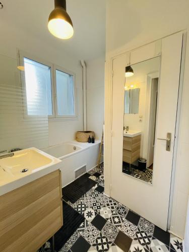une salle de bain avec une baignoire, un lavabo et un miroir dans l'établissement Appartement 40m2 - Hyper Centre, à Brest