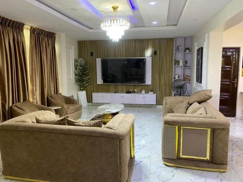 a living room with two couches and a flat screen tv at 3 bedroom duplex in Ikorodu in Ikorodu
