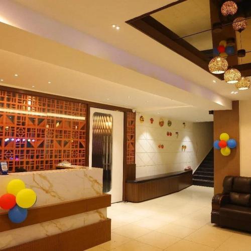 a lobby with a staircase and balloons in a room at Prasasti Hotel in Hanamkonda