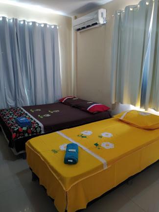 a bedroom with two beds and a yellow blanket at Hotel e Pousada dos Leões in São Luís