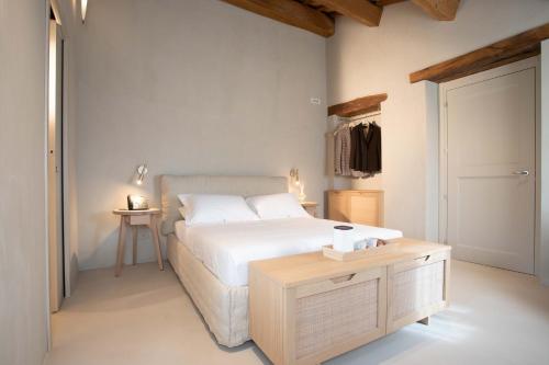 a bedroom with a white bed and a table at Relais La Colombaia in Appignano