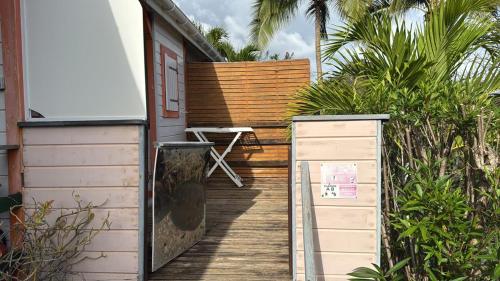 a wooden walkway to a house with a chair on it at Gîtes du Baobab in La Désirade