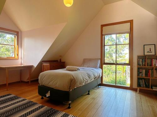 SnugSnug Sanctuary - A gem in the forest 20 min to CBD的一间卧室,在阁楼上设有床和窗户