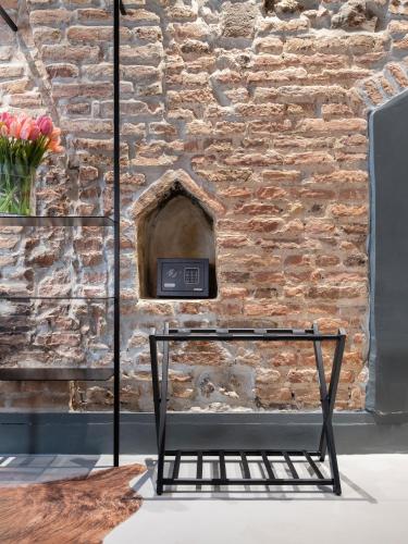 a black bench in front of a stone wall at Officine Cavour CASA DEI LEONI Centro Storico Padova in Padova