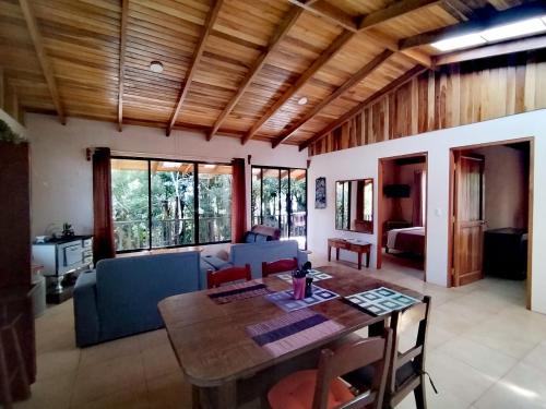 モンテベルデ・コスタリカにあるCasa de Montaña Tica Lindaの木製の天井とテーブルのあるリビングルーム