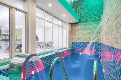 a indoor swimming pool with a water fountain at Alaya Stays Miyabi Suites, Golf Course Road in Gurgaon