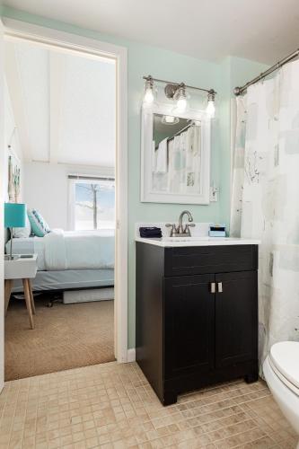 a bathroom with a sink and a toilet and a bed at Lakeshore Luxe in Williamsburg