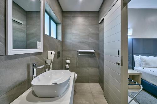bagno con lavandino bianco e letto di Travelodge Kasane a Kasane