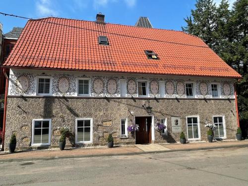 an old stone building with an orange roof at Słoneczne Apartamenty in Sokołowsko