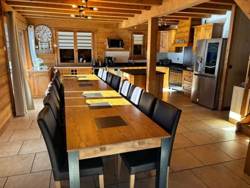- une grande table et des chaises en bois dans la cuisine dans l'établissement Chalet Guytoune, à Morzine