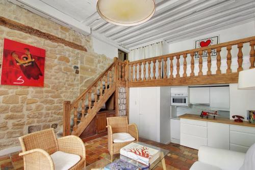 un salon avec un escalier et une cuisine dans l'établissement Loft avec terrasse au coeur du Marais, à Paris
