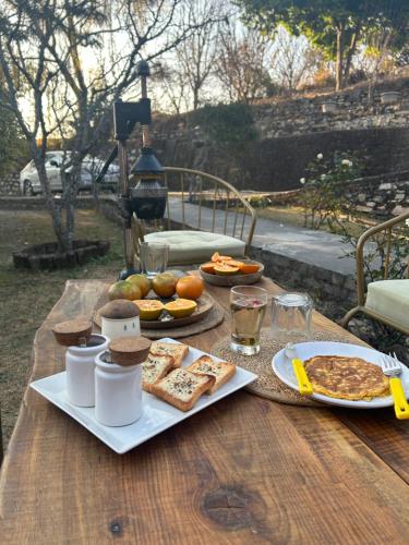 a wooden table with food on top of it at 1111 Villa - The Human Happiness project - MUKTESHWAR - ------------- ---------------- --------------------- ------------------------------ --------------------------------------------- ------------Jacuzzi - Private Property with Garden and Orchard in Mukteswar