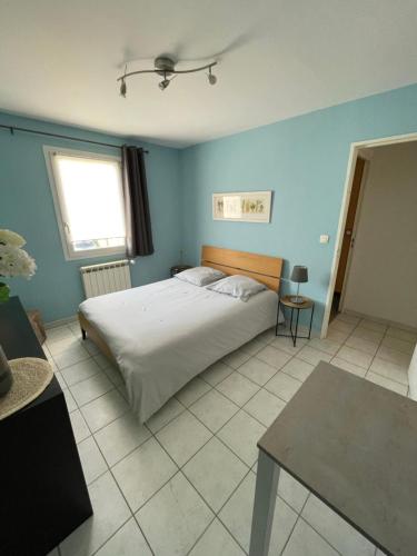 ein Schlafzimmer mit einem Bett und einer blauen Wand in der Unterkunft Charmante villa au calme proche de Montpellier, mer et rivière Animaux acceptés in Saint-Gély-du-Fesc