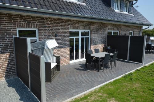 eine Terrasse mit Tisch und Stühlen an einem Haus in der Unterkunft Stadthaus 3, inkl 1 Parkplatz in Fehmarn