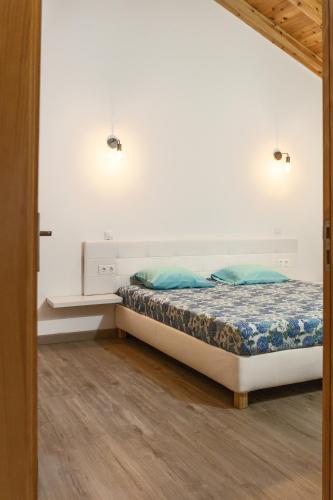 a bedroom with a bed with blue pillows at Blue Ocean View I in Santana