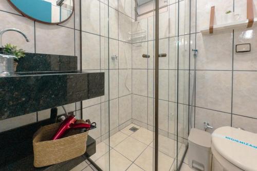a bathroom with a shower with a sink and a toilet at Apartamento Conforto e Prático in Maringá