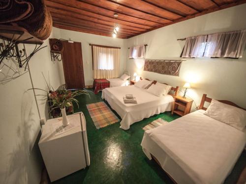 a hotel room with two beds and a couch at Pousada Spa Prana Lorien in Santo Antônio do Leite