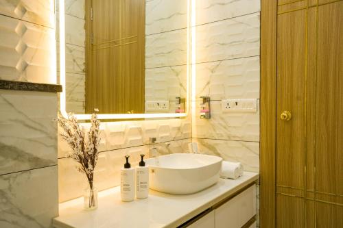 a bathroom with a sink and a mirror at Alaya Stays Miyabi Suites, Golf Course Road in Gurgaon