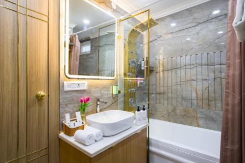 a bathroom with a sink and a shower at Alaya Stays Miyabi Suites, Golf Course Road in Gurgaon