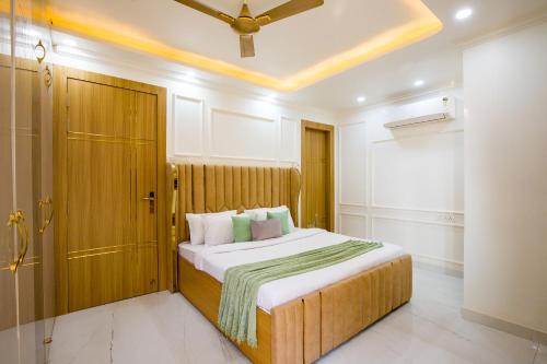 a bedroom with a large bed with a ceiling at Alaya Stays Miyabi Suites, Golf Course Road in Gurgaon