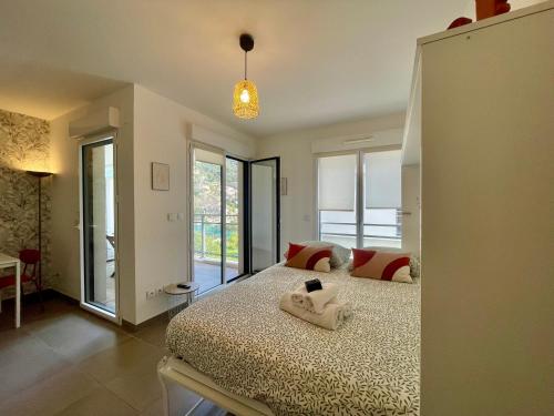 een slaapkamer met een bed en een groot raam bij Charming Studio with Parking near Monaco in Beausoleil