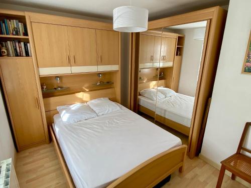 une petite chambre avec un lit et un miroir dans l'établissement La petite Garzette - Appartement Jardin Centre Ville Concarneau, à Concarneau