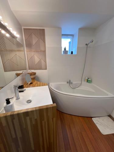 une salle de bain blanche avec une baignoire et un lavabo dans l'établissement maison stef 4 chambres 2 salles de bain 8 personnes, à Valenciennes